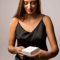 Thumbnail for Woman opening a gift box, revealing the Love Photo Necklace by Brother & Sisters, showcasing personalized elegance.