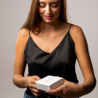 Thumbnail for Person holding a gift box, wearing a black top, showcasing the Photo Projection Bracelet by Brother & Sisters.