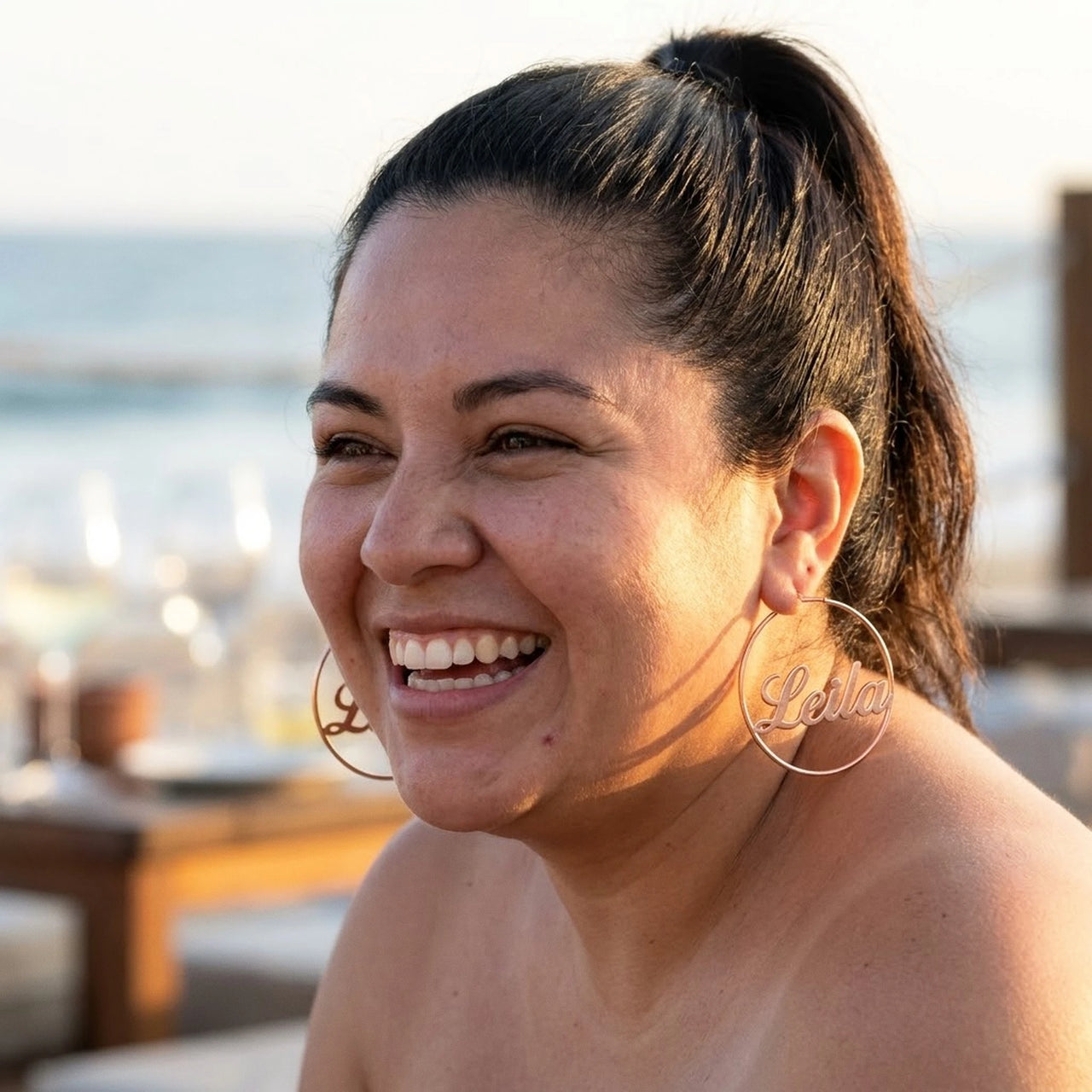 Custom Name Hoop Earrings in Rose Gold worn outdoors, lifestyle shot | SKU: name-hoop-rose-gold-30-mm