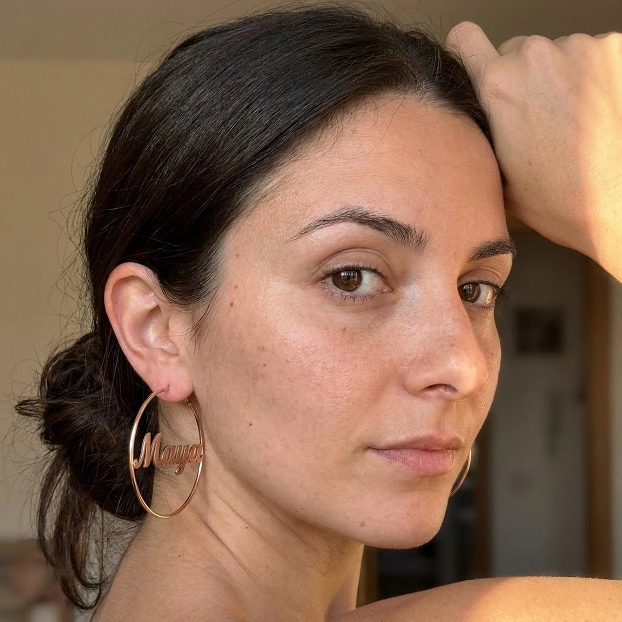 Custom Name Hoop Earrings in Rose Gold worn on the ear, close-up on a model | SKU: name-hoop-rose-gold-30-mm