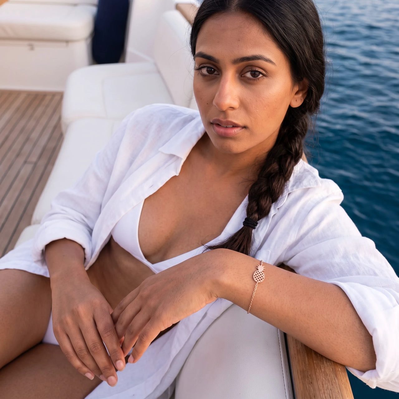 Woman on a yacht wearing the rose gold charm bracelet | SKU: 9178613-rose-gold