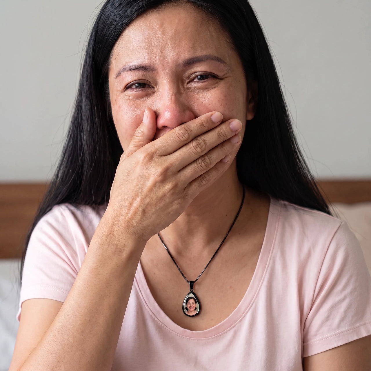 Woman covering her mouth, moved to tears, wearing the black secret drop photo necklace | SKU: TPH-DRPN-BLACK