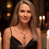 Thumbnail for Woman in a black dress at a candlelit dinner wearing the black secret drop photo necklace | SKU: TPH-DRPN-BLACK