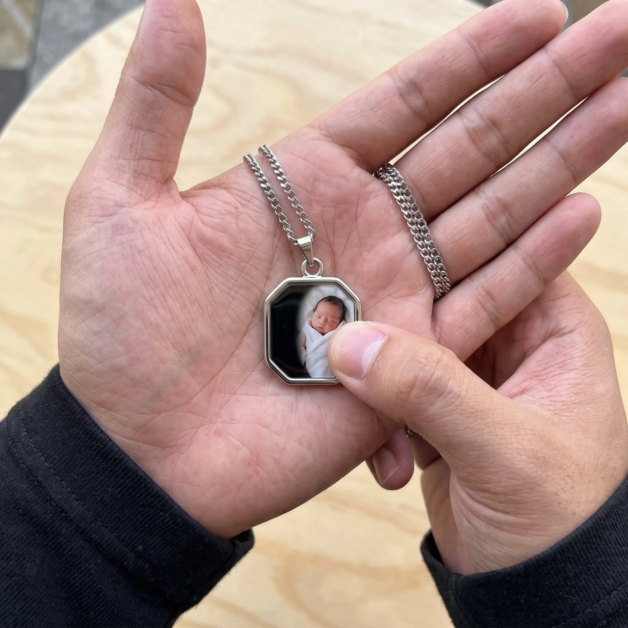 Thumb warming the silver octagon pendant: the hidden photo appears under the thumb while the rest stays black | SKU: TPH-OCTN-SILVER